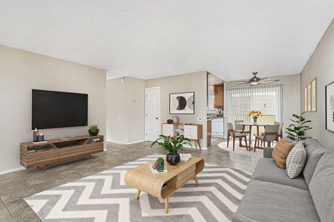 Apartment entrance leading into the living room with a large couch, coffee table and entertainment center with TV at Pacific Sands, San Diego, CA, 92117